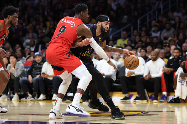 RJ Barrett (#9) of the Raptors guarding Anthony Davis (#3) of the Lakers in a game at Crypto.com Arena.