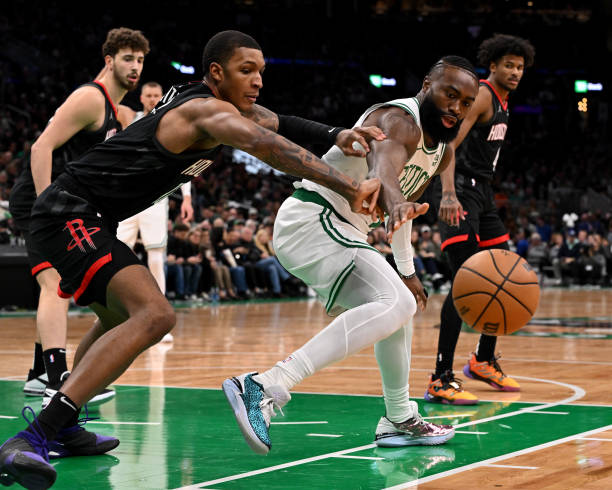 Jaylen Brown #7 of the Celtics and Jabari Smith Jr. #10 of the Rockets reach for a loose ball during the first quarter at the TD Garden.