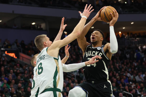 Giannis Antetokounmpo of the Bucks drives to the basket against Kristaps Porzingis of the Celtics in a game at Fiserv Forum.