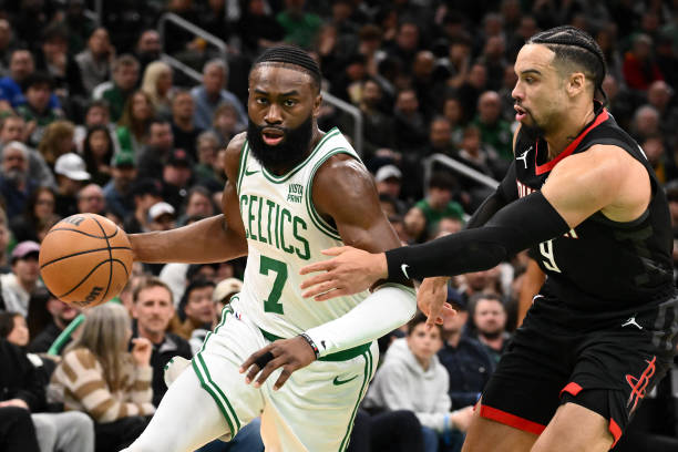 Jaylen Brown (#7) of the Boston Celtics drives to the basket against Dillon Brooks (#9) of the Houston Rockets at TD Garden in Boston.
