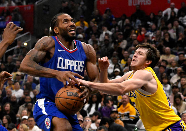 Kawhi Leonard of the Clippers drives to the basket against Austin Reaves of the Lakers in a NBA game at Crypto.com Arena.