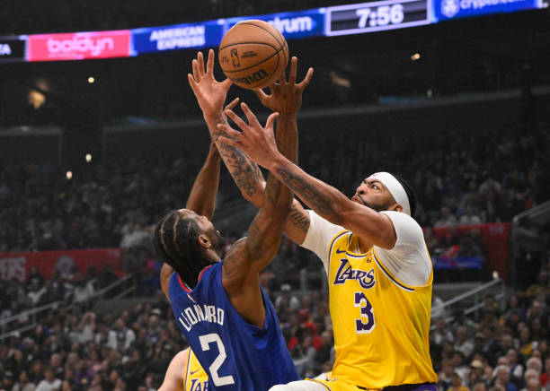 Anthony Davis of the Lakers and Kawhi Leonard of the Clippers compete for a loose ball in an NBA game at Crypto.com Arena.