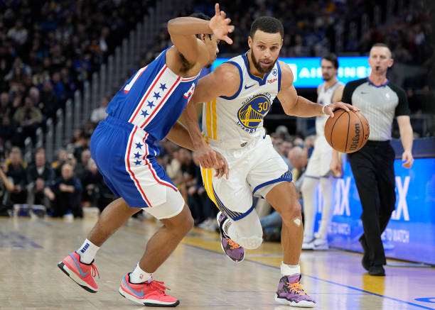 Steph Curry drives past Jaden Springer during the Warriors vs 76ers game at Chase Center in San Francisco.