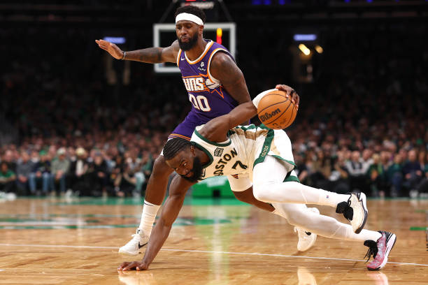 Jaylen Brown of the Boston Celtics recovers with the ball after tripping ahead of Royce O'Neale of the Phoenix Suns during the second half at TD Garden.