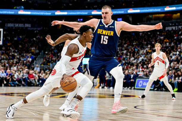 RJ Barrett of the Raptors drives against Nikola Jokic of the Nuggets in the second half at Ball Arena.